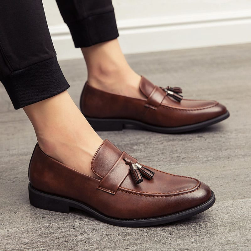 Brauner Herren-Loafer mit Quaste, getragen zu einer hellen Hose Bild