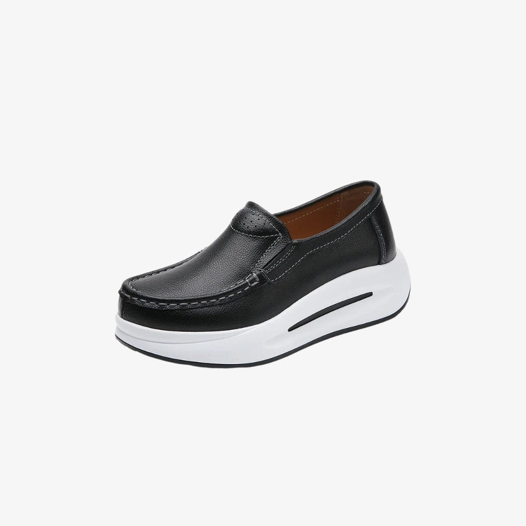 Plateau-Loafer für Damen aus schwarzem Kunstleder mit dicker weißer Sohle für einen modernen und bequemen Stil. Ihr minimalistisches Design mit sichtbaren Nähten und leichtem Einstieg ist perfekt für einen eleganten und zugleich lässigen Look.