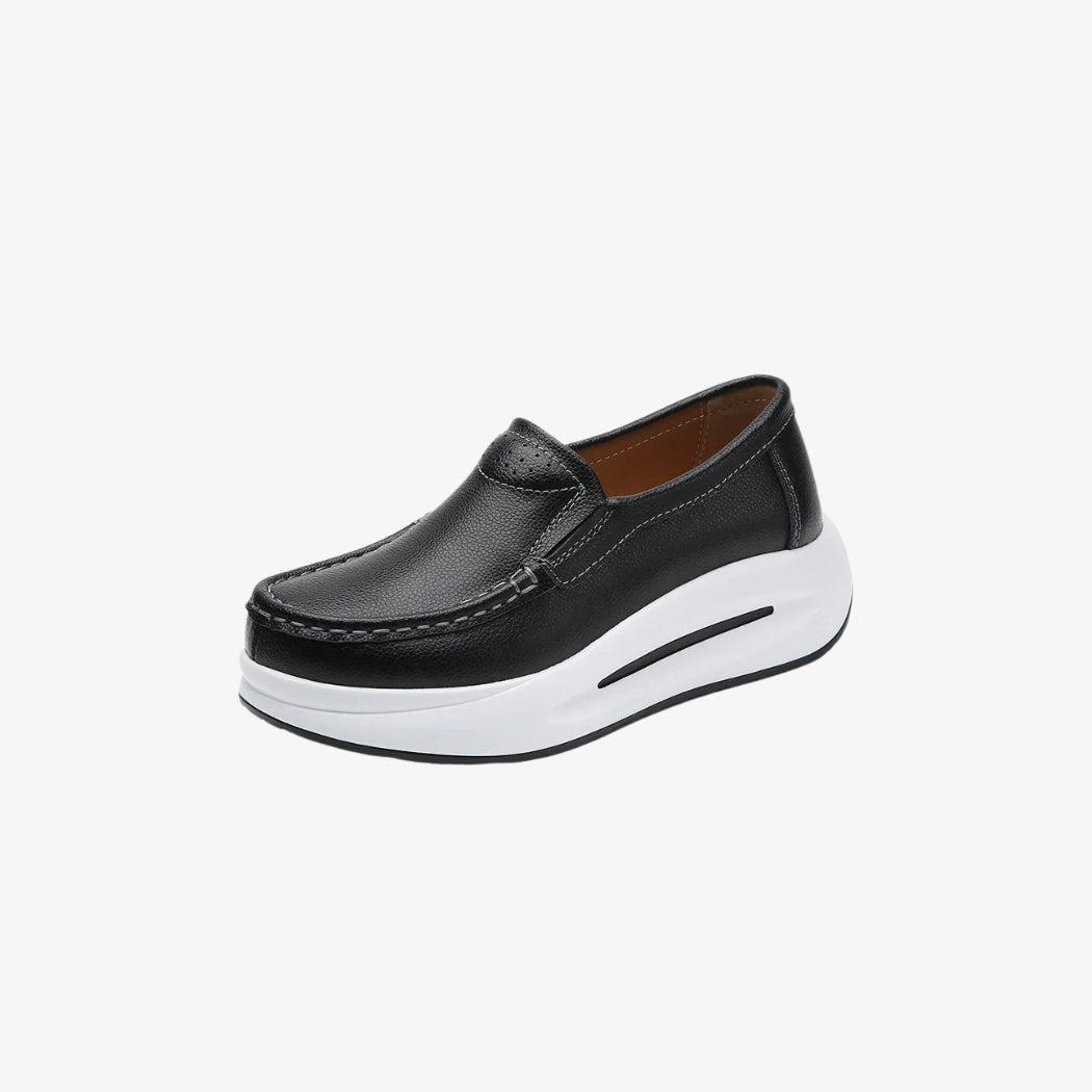 Plateau-Loafer für Damen aus schwarzem Kunstleder mit dicker weißer Sohle für einen modernen und bequemen Stil. Ihr minimalistisches Design mit sichtbaren Nähten und leichtem Einstieg ist perfekt für einen eleganten und zugleich lässigen Look.