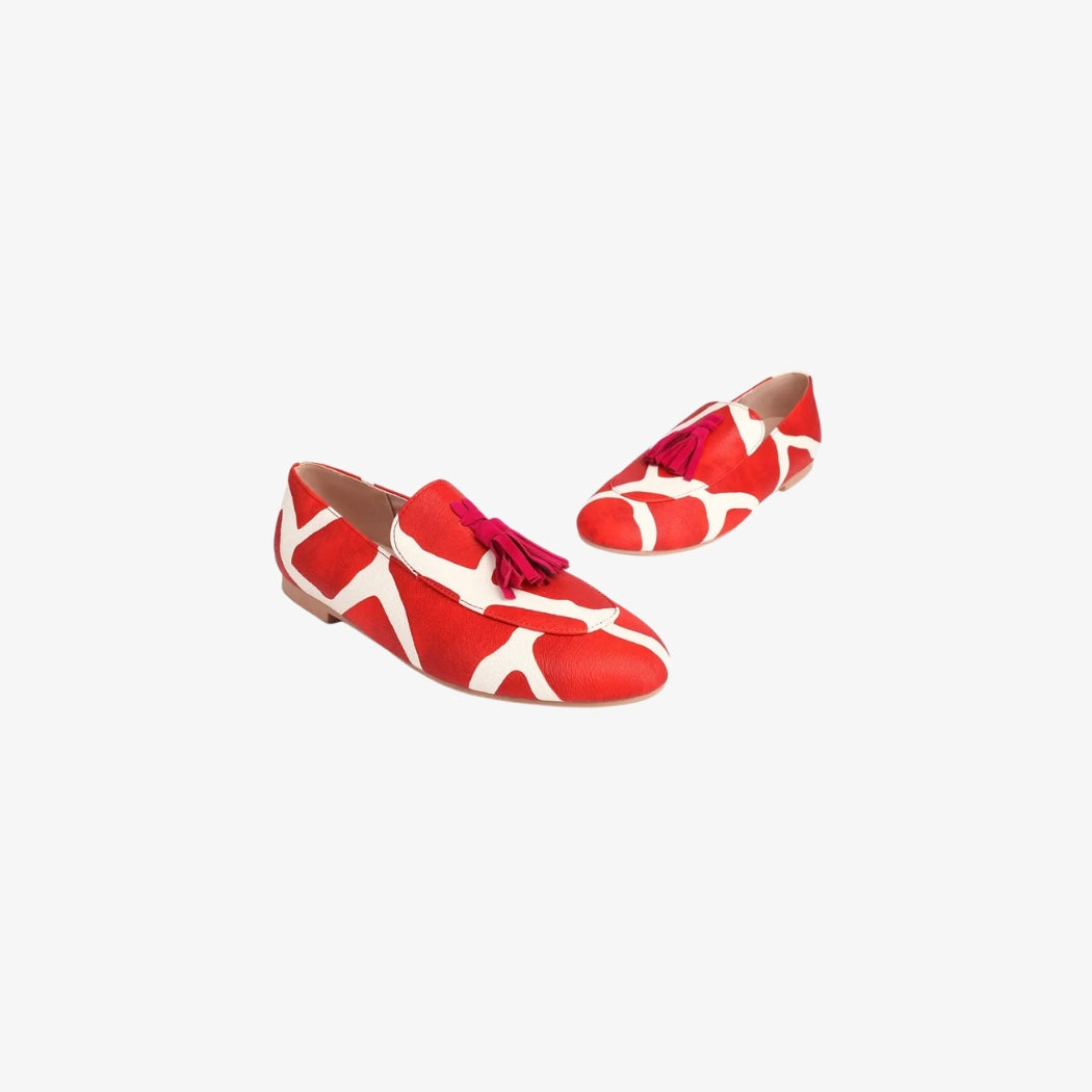 Loafer für Damen in Rot und Weiß mit mutigem grafischem Muster, oben mit dekorativen roten Quasten verziert. Diese flachen Schuhe verbinden Originalität und Komfort, perfekt für einen einzigartigen Akzent bei lässigen oder schicken Outfits.
