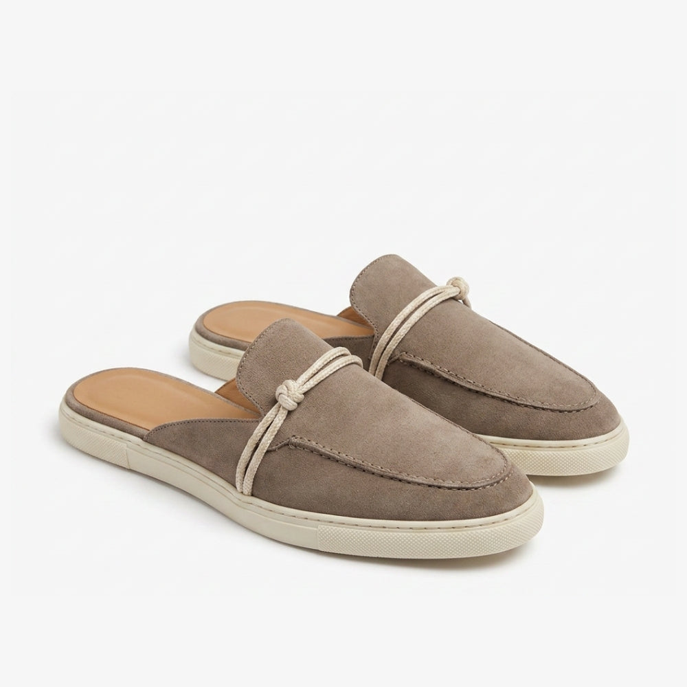 Loafer-Mule aus echtem Wildleder in Braun-Taupe mit beiger Sohle und beigem Riemen auf grauem Hintergrund