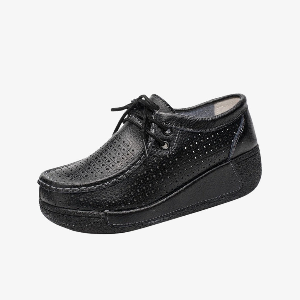 Loafer für Damen aus schwarzem Leder mit perforiertem Design für bessere Belüftung. Die eleganten Schuhe mit Schnürung für eine präzise Passform haben schwarze Plateausohlen, die guten Halt und optimalen Komfort den ganzen Tag bieten.