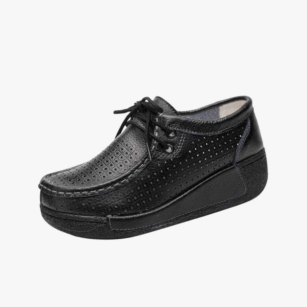 Loafer für Damen aus schwarzem Leder mit perforiertem Design für bessere Belüftung. Die eleganten Schuhe mit Schnürung für eine präzise Passform haben schwarze Plateausohlen, die guten Halt und optimalen Komfort den ganzen Tag bieten.