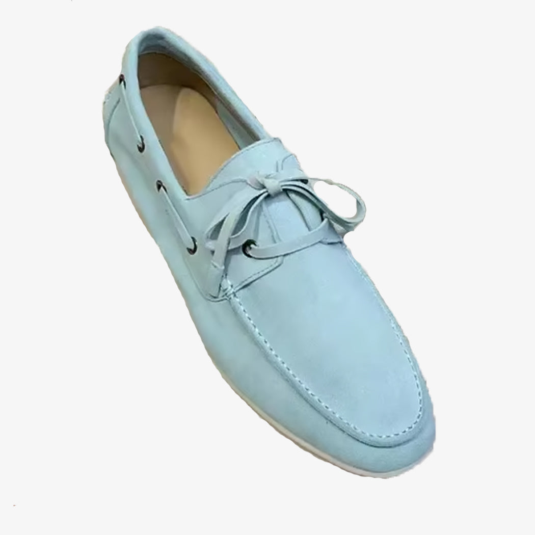 Ein eleganter Bootsschuh aus hellblauem Wildleder auf weißem Hintergrund