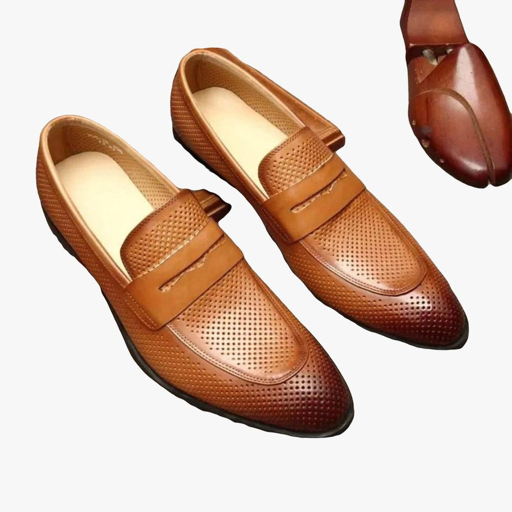 Auf grauem Hintergrund ist ein Paar brauner spitzer Loafer aus echtem Leder für Herren zu sehen