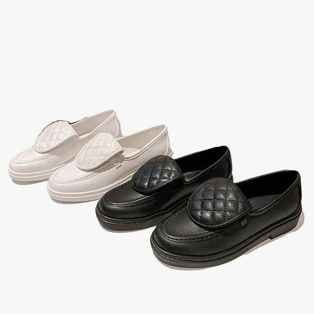 Zwei Paar Loafer mit gesteppter Oberseite und Blockabsatz für Damen, ein weißes und ein schwarzes Paar nebeneinander