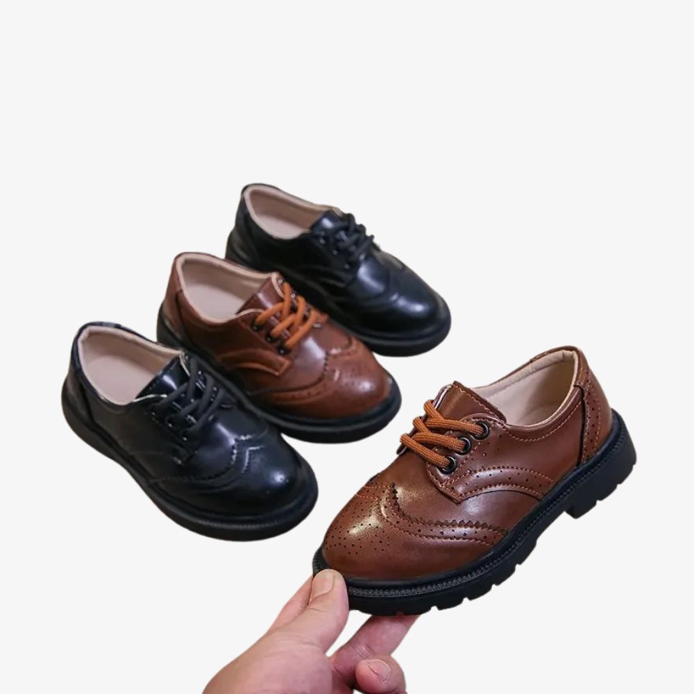 2 Paar schwarze und braune Mokassins, von denen ein brauner Schuh in einer Hand gehalten wird.