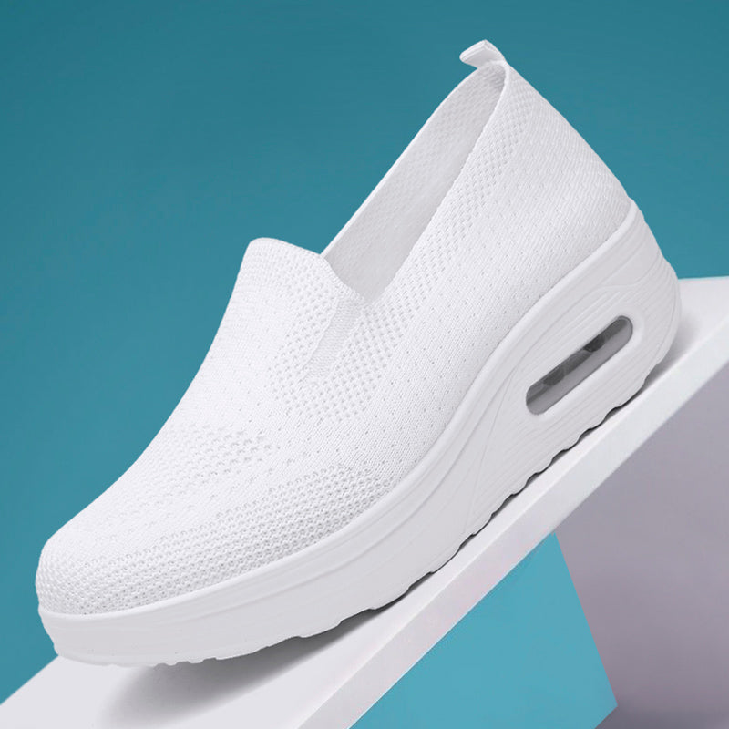 Weißer Schuh auf einer weißen Unterlage mit türkisblauem Hintergrund