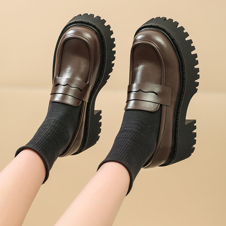 Braune Plateauslipper aus Leder für Frauen mit beigem Hintergrund