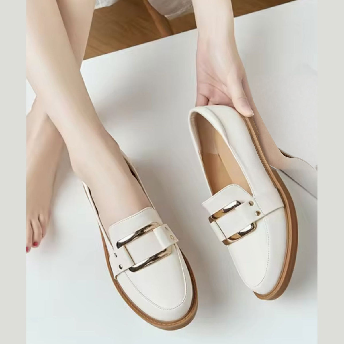 Paar beige Damen-Mokassins mit goldener Schnalle
