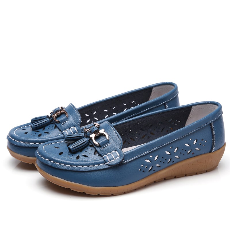 Blaue Mokassins mit Lochmuster auf weißem Hintergrund.