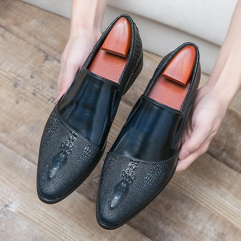 Ein Paar Hände, die blaue Schuhe mit Krokodilmuster halten