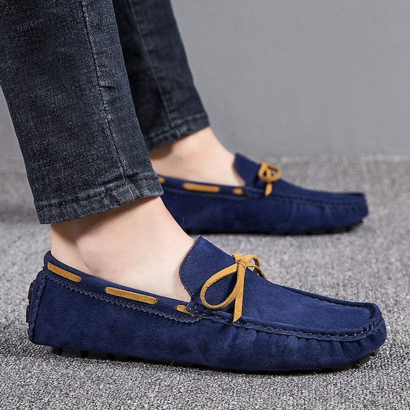 Füße eines Mannes im Profil, der Jeans und klassische blaue Bootsmokassins trägt