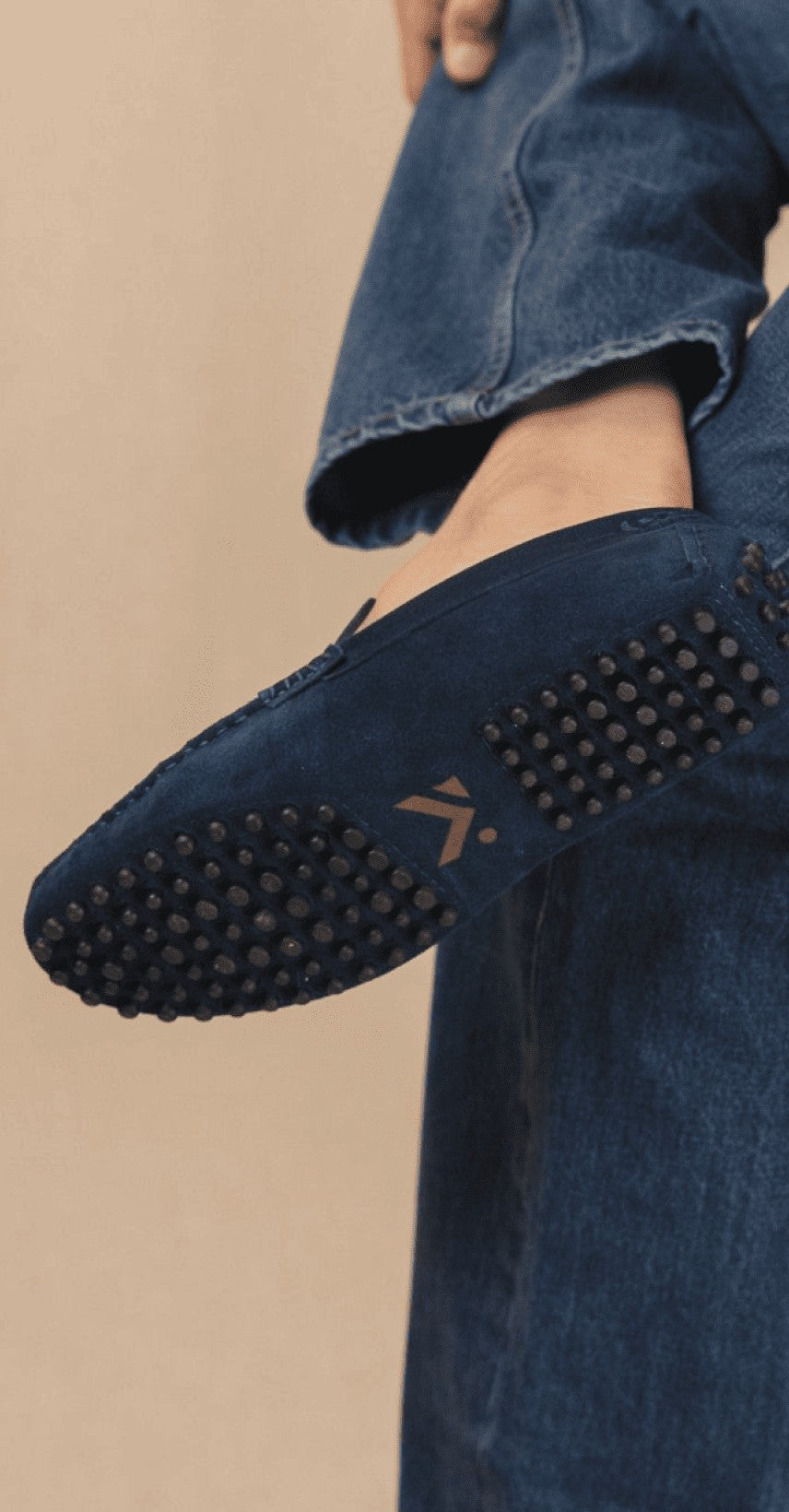 Marineblauer Wildleder-Mokassin in der Hand