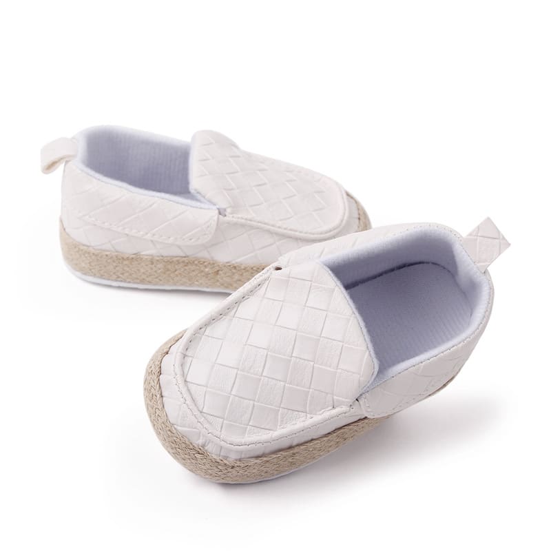 Ein blauer Mokassin mit quadratischer Spitze, geflochtenen Lederriemen und beigem Seil um den Schuh