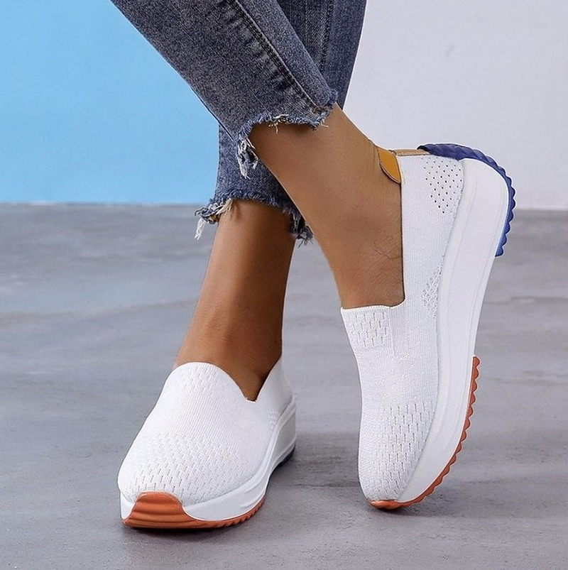 Foto von orthopädischen Mokassins Typ Sneakers aus atmungsaktivem weißen Netzgewebe mit einer farbigen Sohle bis zur Rückseite der Ferse.