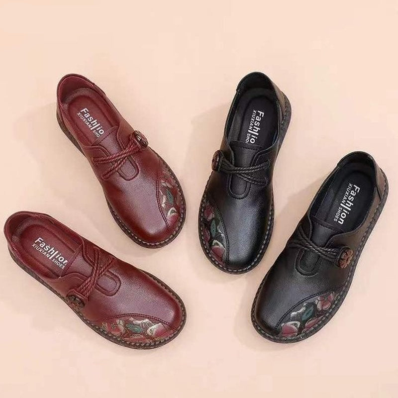 Zwei Paar Schuhe stehen auf dem Boden. Ein rotes und ein schwarzes mit Blumenmuster auf der Vorderseite.