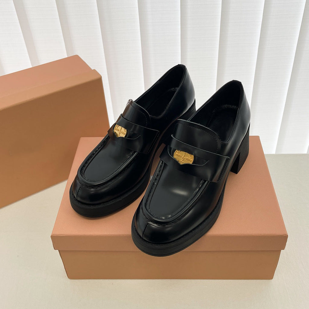 Schwarze Mokassins auf einem braunen Schuhkarton