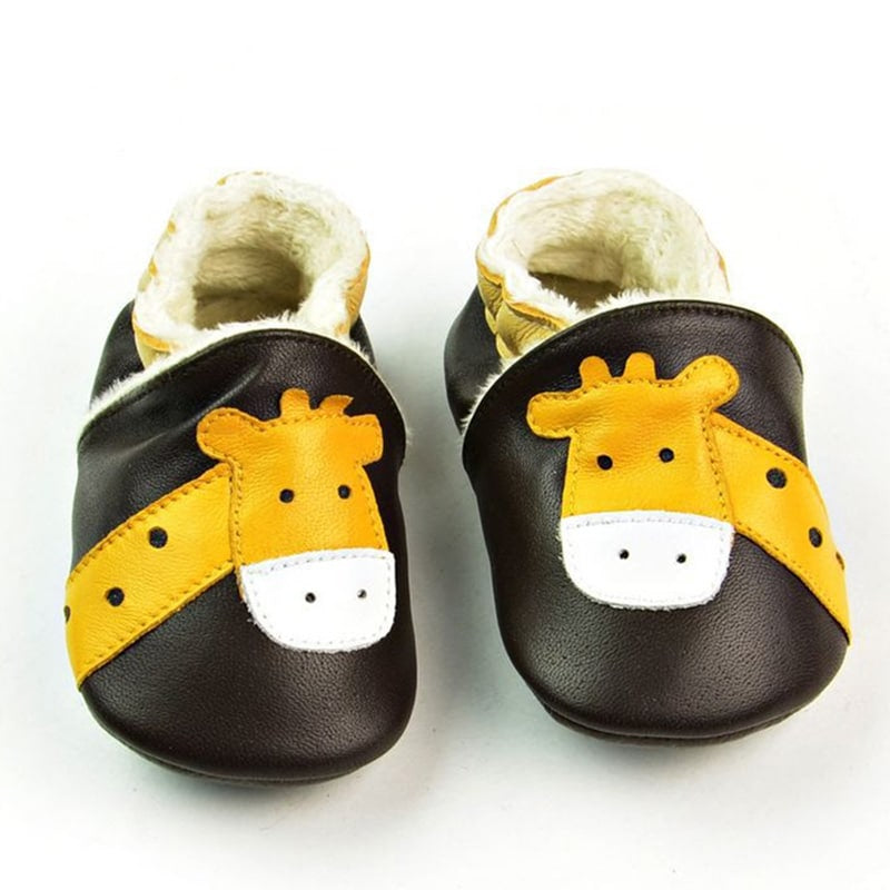 Weiche Baby-Mokassins aus dunkelbraunem Leder mit gelbem Giraffenkopf. Auf der Innenseite ist weicher, beiger Plüsch zu sehen.