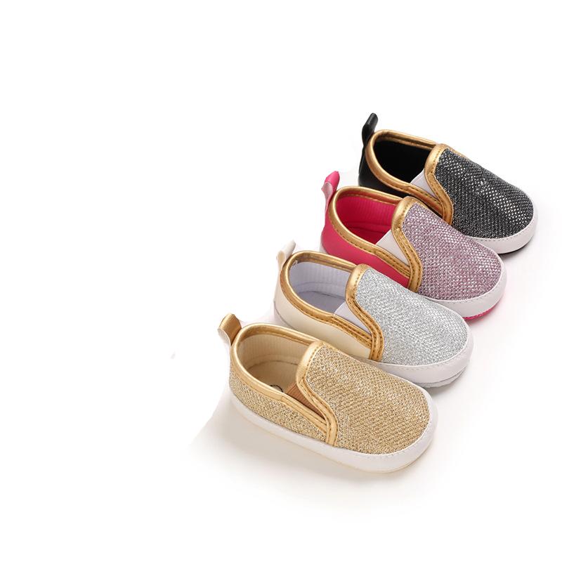 Vier Mokassins in Gold, Silber, Rosa und Schwarz diagonal aufgereiht
