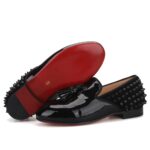 Schwarze Mokassins in Lackoptik mit Stacheln auf der Rückseite des Schuhs.