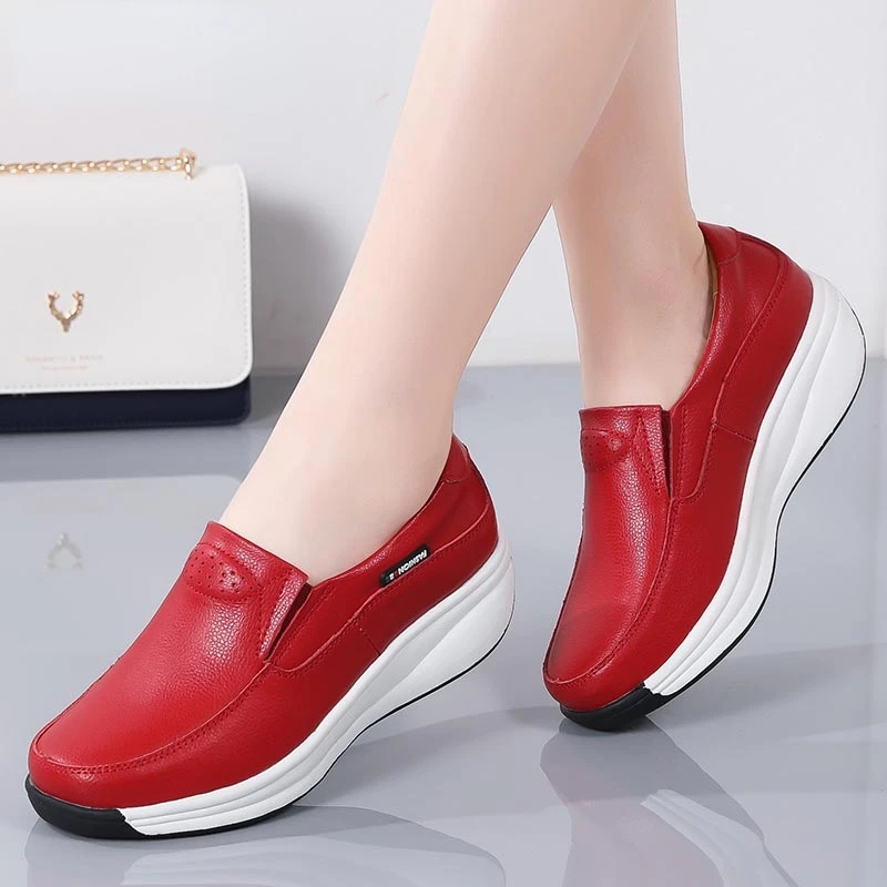 Fußpaar mit roten Schuhen mit weißer Sohle