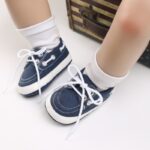 Babybeine mit weißen Socken und blauen Mokassins im Bootsstil