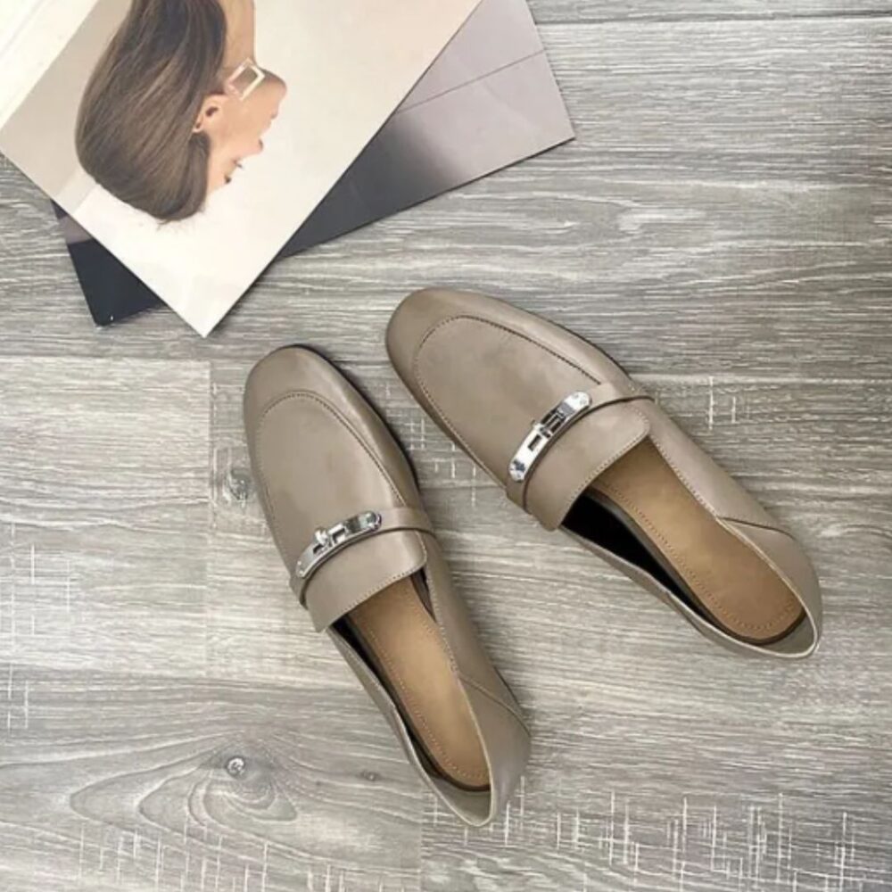 on voit sur un sol gris clair des mocassins gris légers à talons carrés en cuir véritable pour femme
