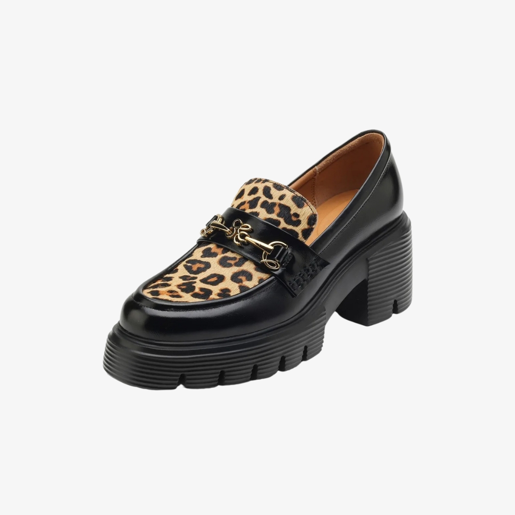 Mocassins pour femmes en cuir noir, élégants et modernes, ornés d'un dessus en motif léopard pour une touche audacieuse. Une boucle métallique dorée ajoute une finition sophistiquée, tandis que les talons épais et crantés offrent à la fois style et stabilité.