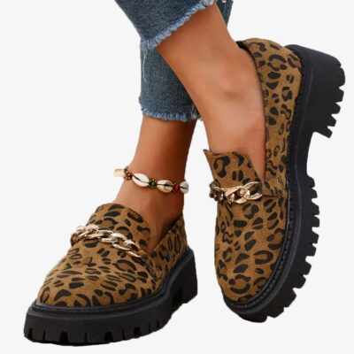Paar Mokassins mit Leopardenmuster aus Wildleder und Plateau mit Kette, getragen mit Jeans und Fußkettchen aus Muscheln