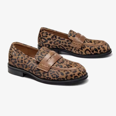 Paar Mokassins mit Leopardenmuster aus Leder mit Riemen über dem Spann vor weißem Hintergrund