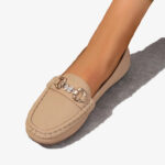 Beige Mokassins aus Kunstleder mit Kette und Strass-Schmetterling vor weißem Hintergrund