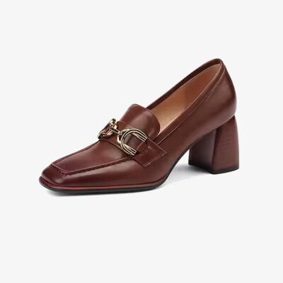 Ein brauner Damen-Loafer mit Absatz aus Leder im Vintage-Stil vor einfarbig weißem Hintergrund
